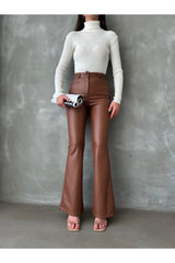 Kadın acı kahve deri pantolon, yüksek bel ve Bol kesim ile şık görünüm sunar