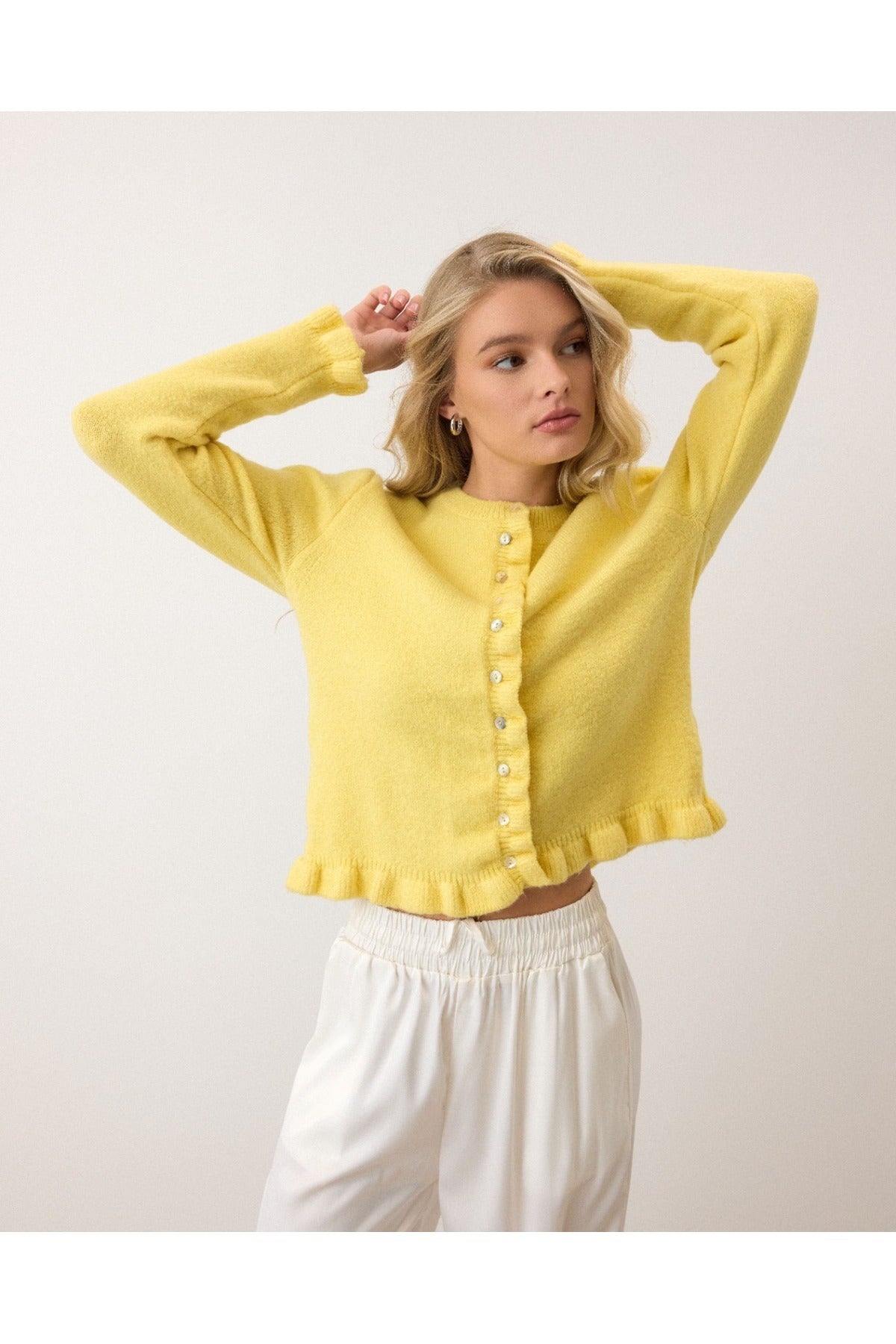 Sarık beyaz düğmeli peluş hırka, şık ve rahat bir görünüm için ideal tercihtir.