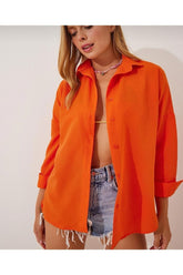 Kadın turuncu oversize gömlek, yaz modasına uygun rahat bir görünüm sunuyor.