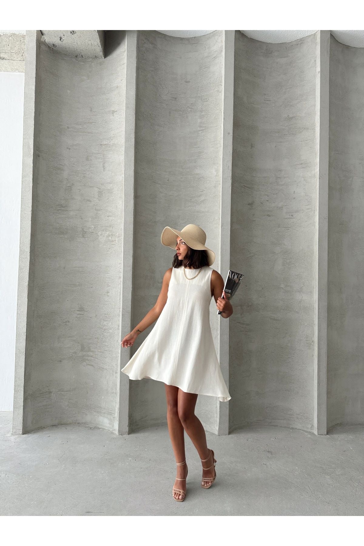 Beyaz Aec Prive keten yazlık elbise, geniş kenarlı şapka ve şık ayakkabılarla kombinlenmiş