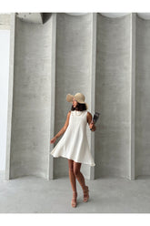 Beyaz Aec Prive keten yazlık elbise, geniş kenarlı şapka ve şık ayakkabılarla kombinlenmiş