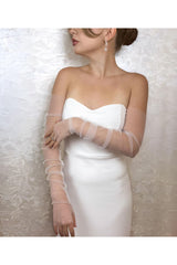 Aec Prive siyah tül eldiven, zarif bir beyaz elbise ile kombinlenmiş şık bir görünüm sunuyor.