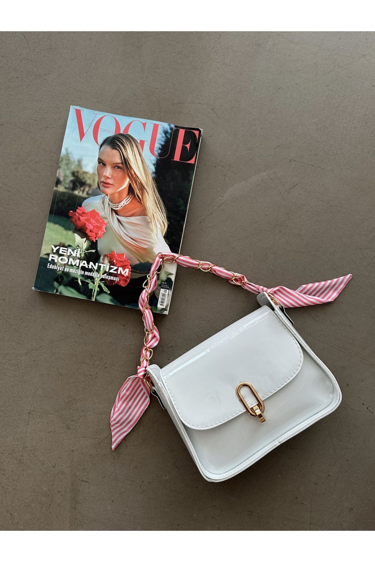 Aec Prive beyaz omuz çantası, şık askı ipleriyle Vogue dergisinin yanında.