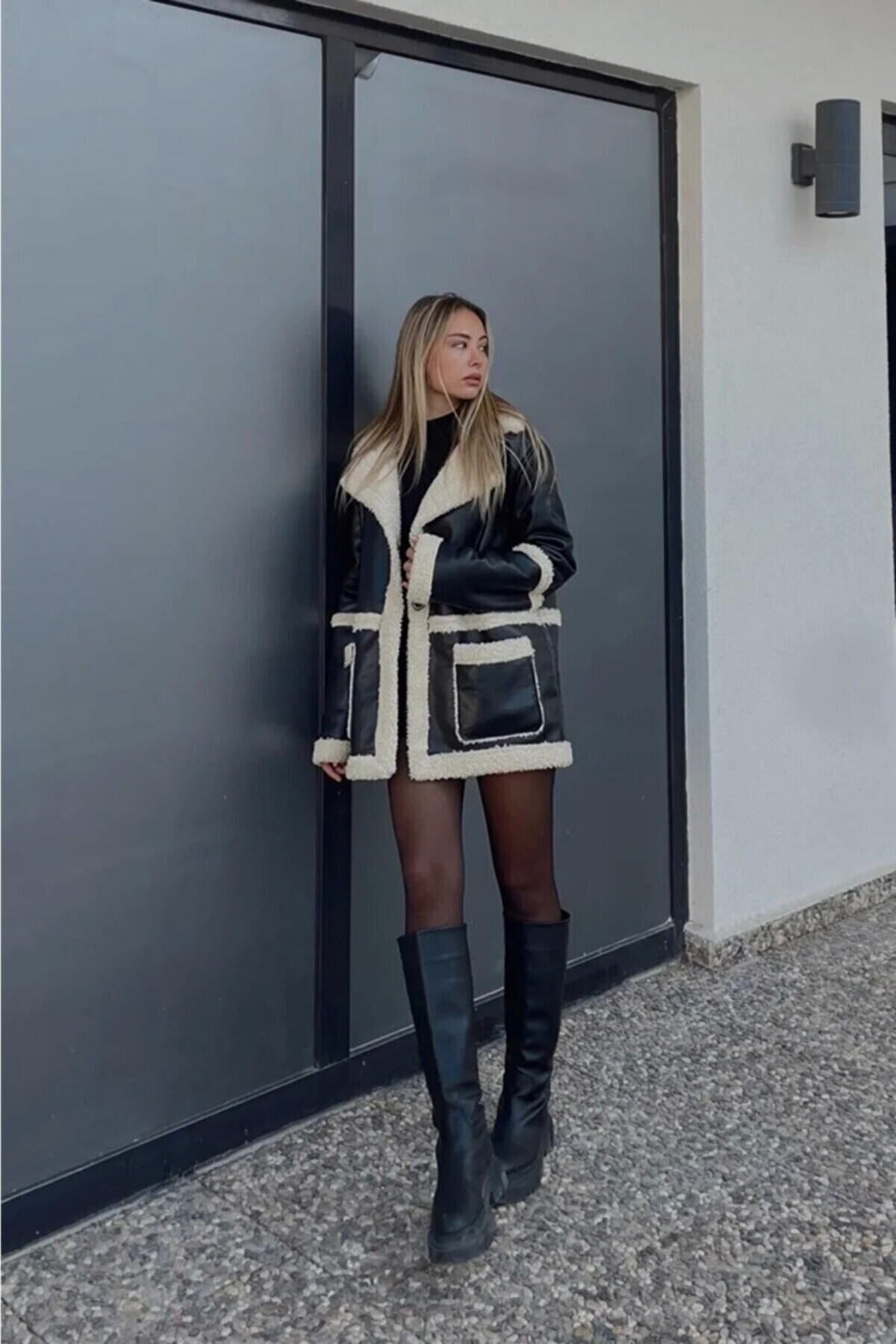 Içi kürklü siyah deri mont ile şık bir görünüm elde eden moda modeli