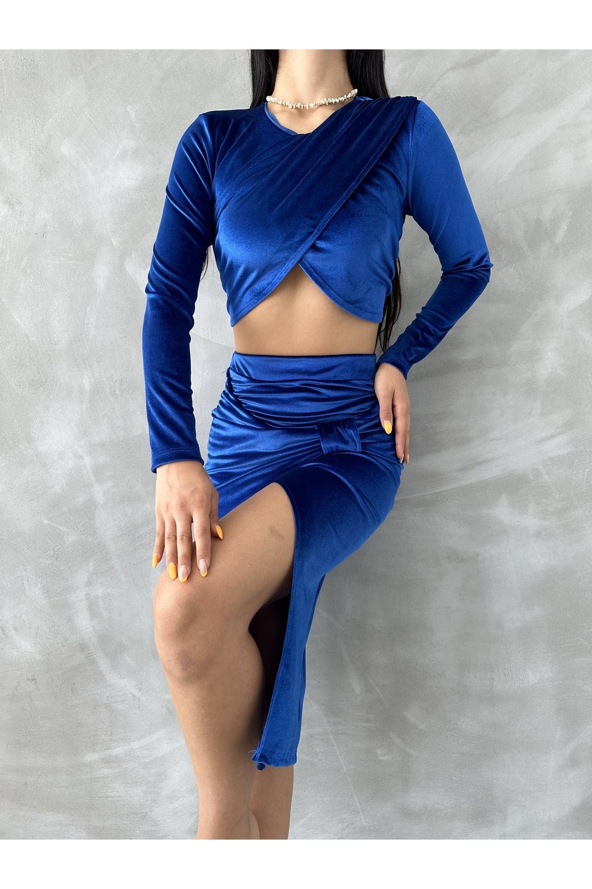 Mavi kadın kadife bluz etek takım, uzun kollu bluz ve yırtmaçlı etek ile şık görünüm sunuyor.