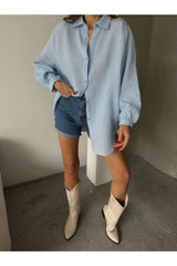 Aec Prive kadın pamuklu oversize gömlek mavi renk ile şort ve çizmelerle kombinlenmiş