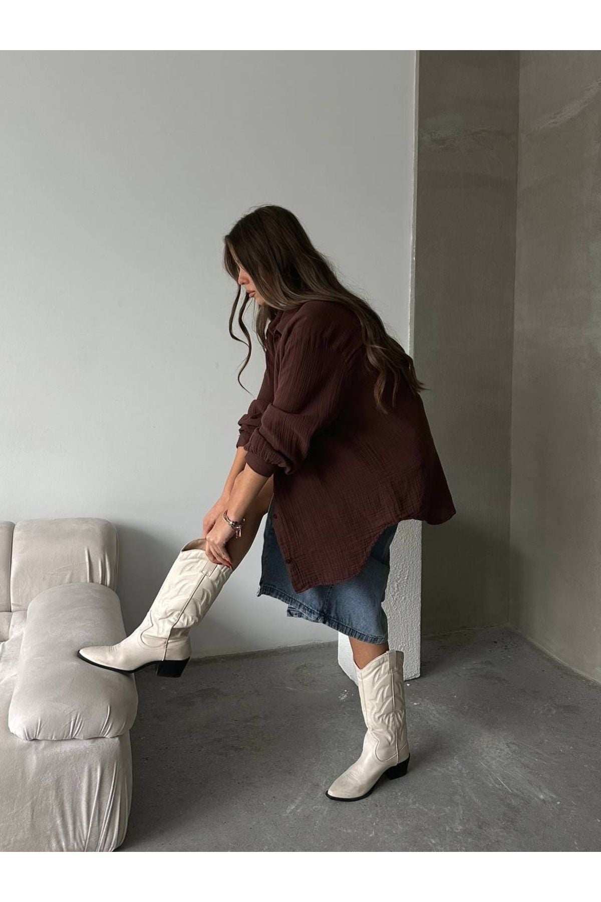 Kahverengi Aec Prive kadın pamuklu oversize gömlek, mavi etek ve beyaz kovboy botlarıyla kombinlenmiş