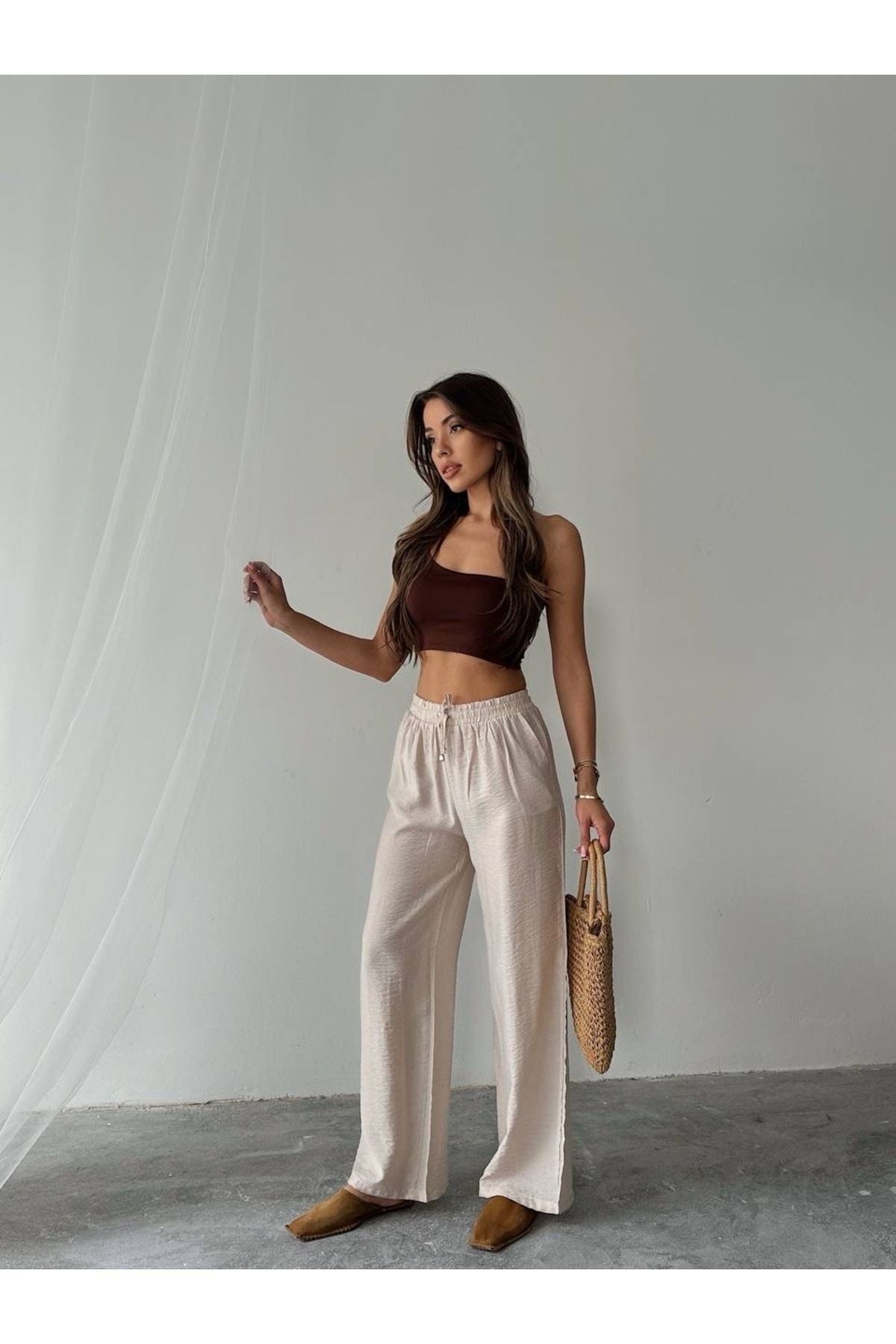 Aec Prive kadın pamuklu palazzo pantolon ile rahat bir yaz görünümü, şık bir üst ve aksesuarlarla tamamlanmış.