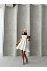 Beyaz Aec Prive keten yazlık elbise, geniş kenarlı şapka ve şık ayakkabılarla kombinlenmiş