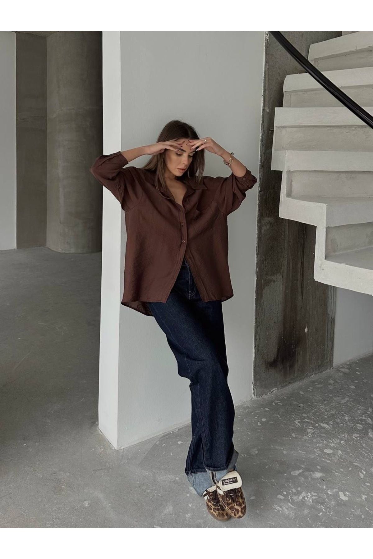 Kahverengi oversize kadın gömlek, şık görünüm için rahat bir şekilde kombinlenmiştir