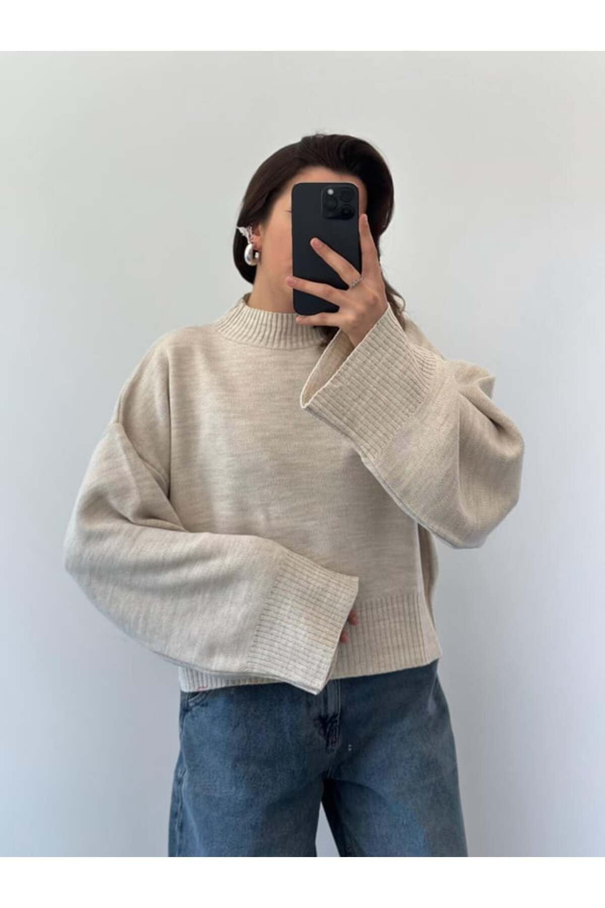 Bej renk oversize kadın kazak, geniş kollu ve modern tasarıma sahip, rahat bir görünüm için ideal.