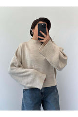 Bej renk oversize kadın kazak, geniş kollu ve modern tasarıma sahip, rahat bir görünüm için ideal.