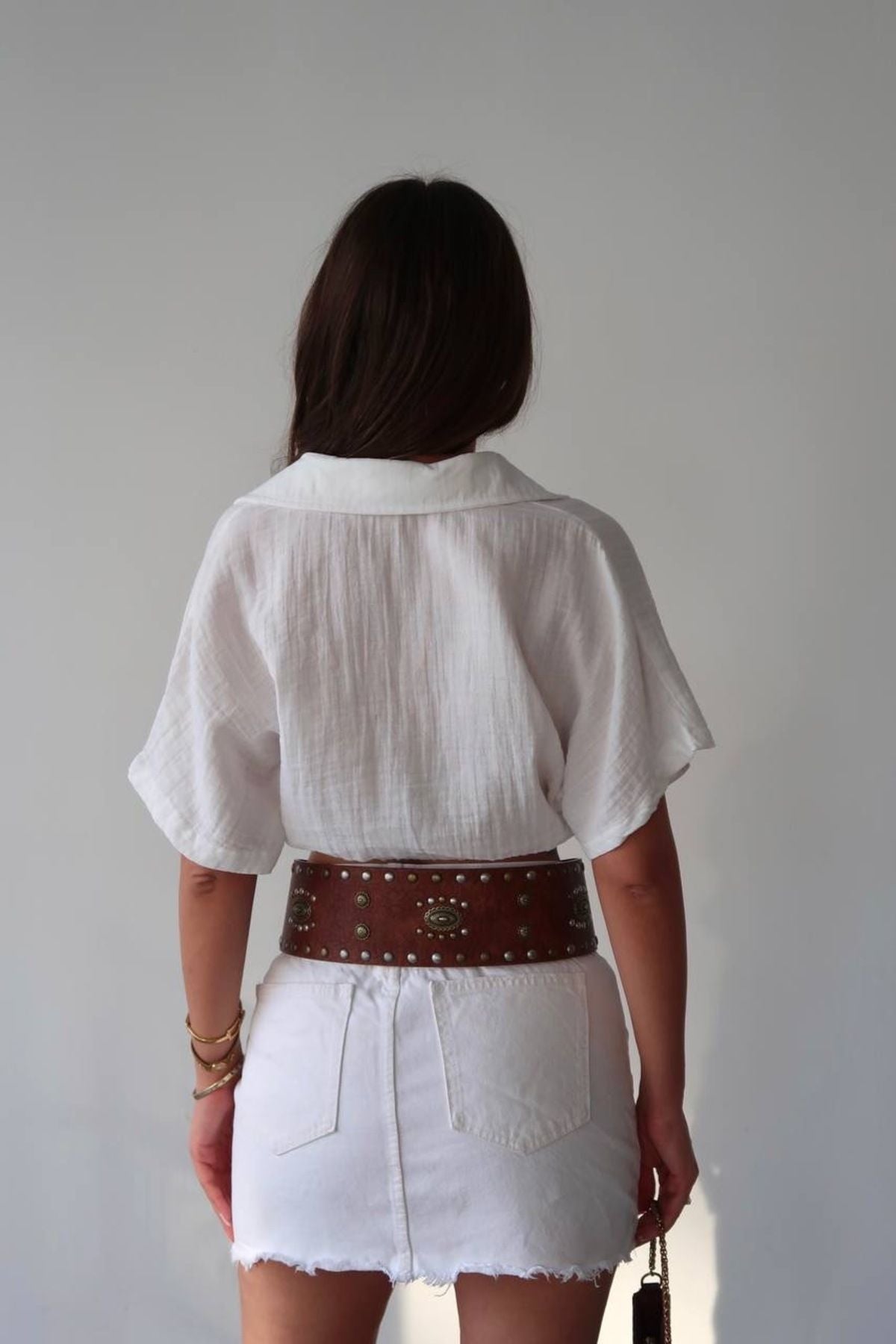 Özel tasarım kadın bağlamalı gömlek, beyaz renk ve şık bir bel kemeri ile modern görünüm sağlıyor.